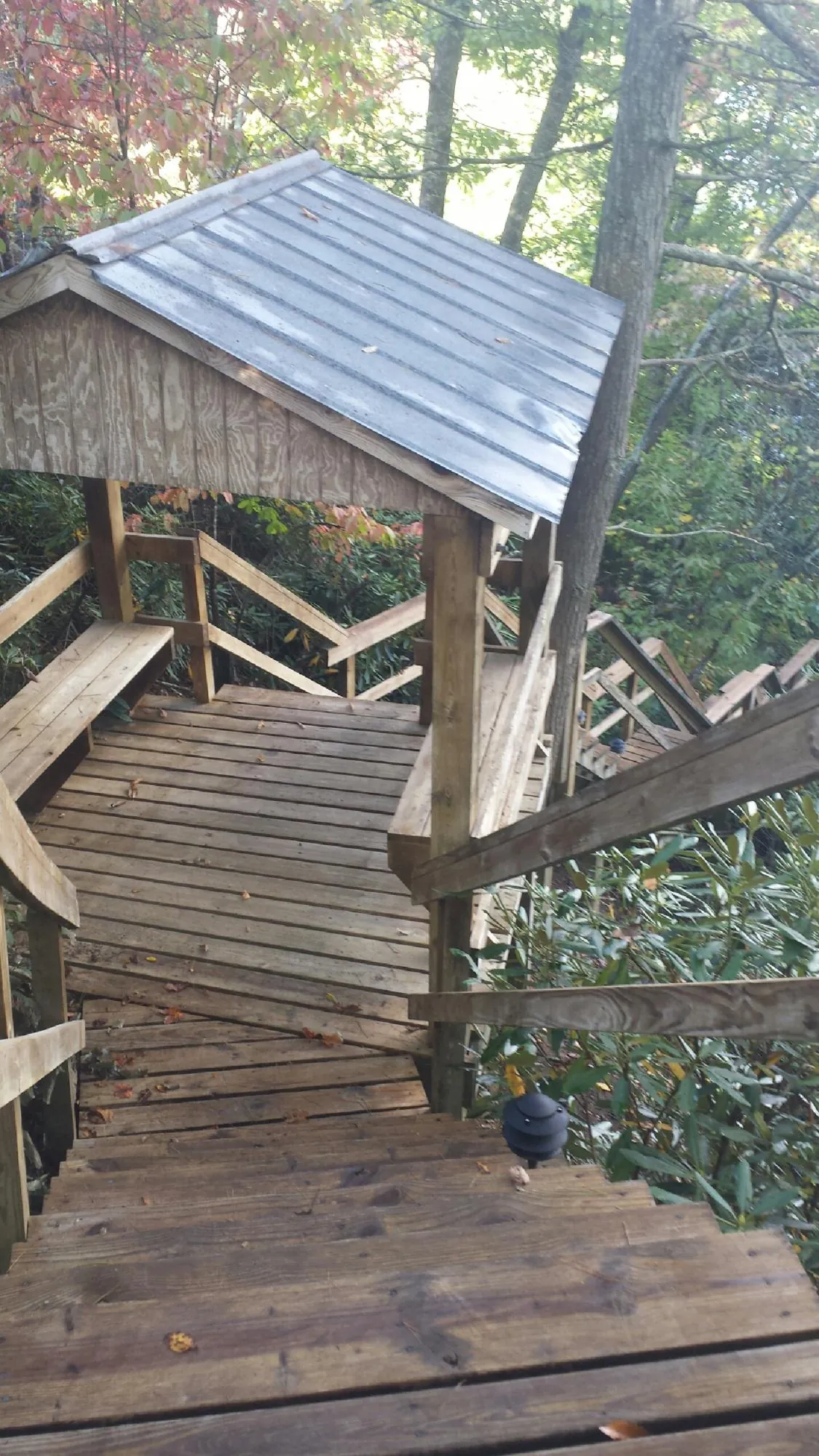 Metal roofed shelter over wooden steps on a wooded walkway — Skylight Repair & Installation work by our crew in Deposit